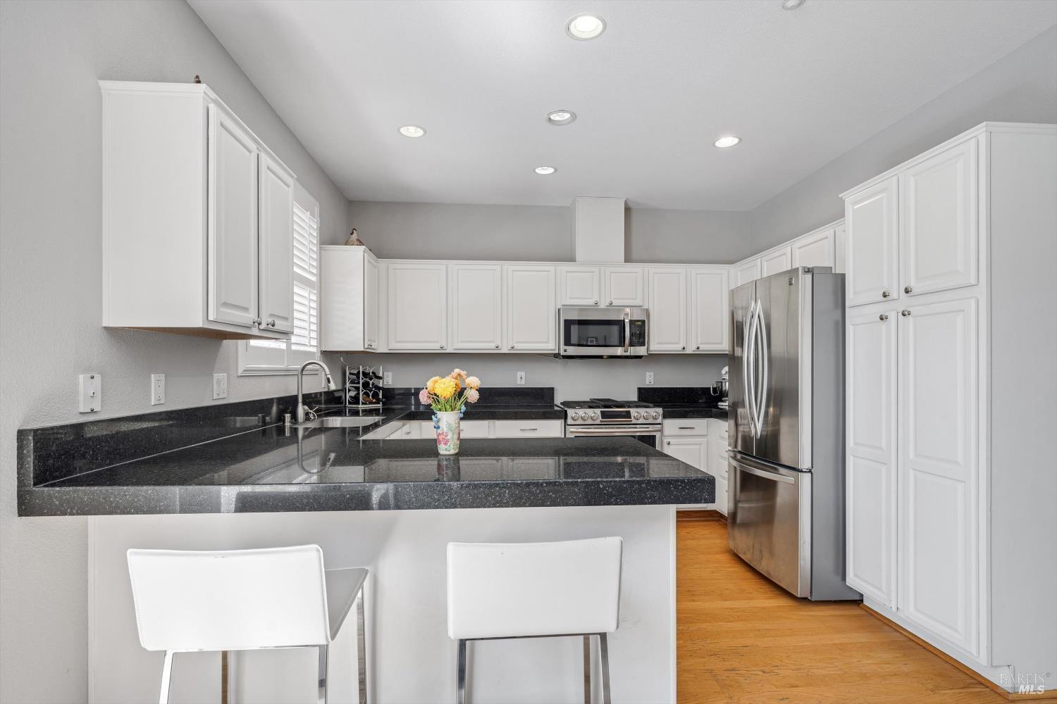 1703 Spur Ridge Lane Healdsburg, CA 95448 - Photo 14 of 28 a kitchen with stainless steel appliances granite countertop a refrigerator a stove a sink a dining table and chairs