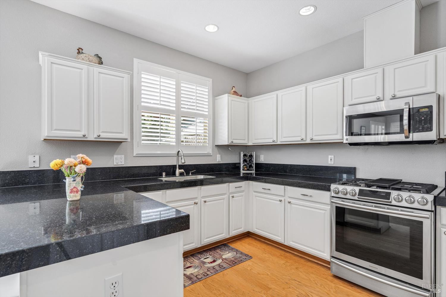 1703 Spur Ridge Lane Healdsburg, CA 95448 - Photo 15 of 28 a kitchen with granite countertop a sink a stove a microwave and cabinets
