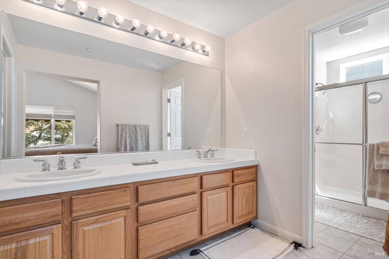 1703 Spur Ridge Lane Healdsburg, CA 95448 - Photo 21 of 28 a bathroom with a double vanity sink and mirror