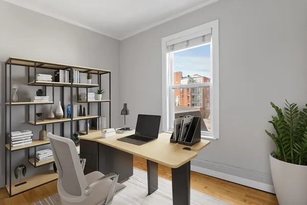 a view of a workspace with furniture and wooden floor