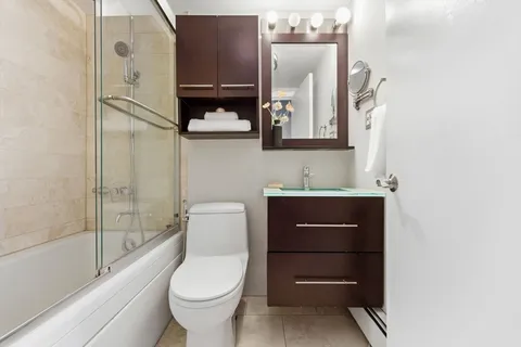a bathroom with a toilet a sink and mirror
