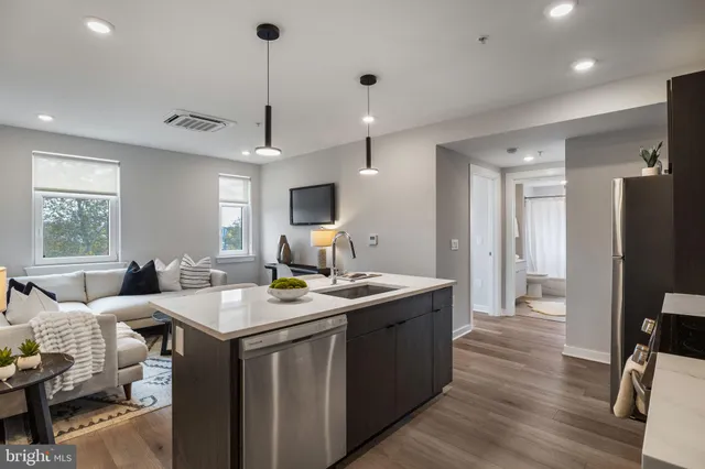 a view of a kitchen counter space a sink wooden floor and a window