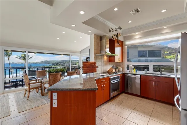 a kitchen with stainless steel appliances granite countertop a refrigerator a sink a stove and a refrigerator