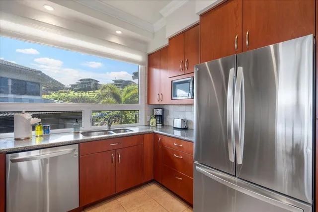 a kitchen with stainless steel appliances granite countertop a refrigerator sink and microwave