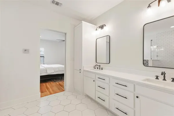 a en suite bathroom with a double vanity sink and mirror