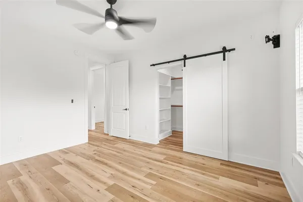 a view of a room with wooden floor and ceiling fan