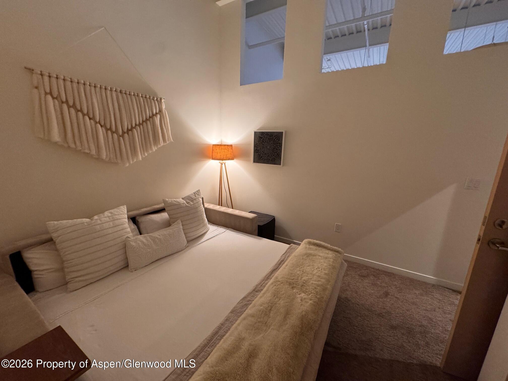 361 Robinson Street, Unit 232 Basalt, CO 81621 - Photo 10 of 26 a bedroom with a bed and a night stand