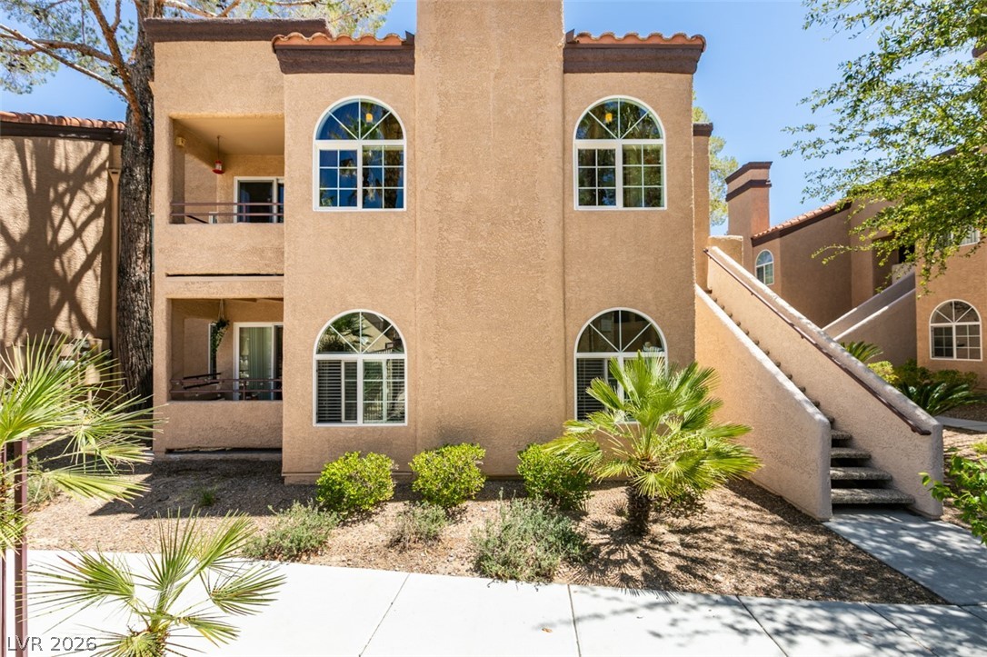 9325 West Desert Inn Road, Unit 244 Las Vegas, NV 89117 - Photo 2 of 55 This stucco exterior building features arched windows and multiple balconies, offering a welcoming facade.