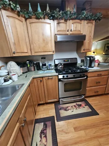 a kitchen with stainless steel appliances granite countertop a sink and a stove
