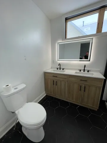 a bathroom with a toilet sink and mirror