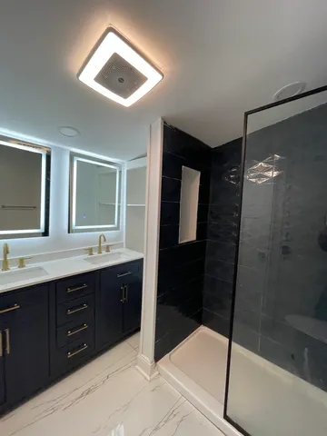 a bathroom with a double vanity sink toilet and shower