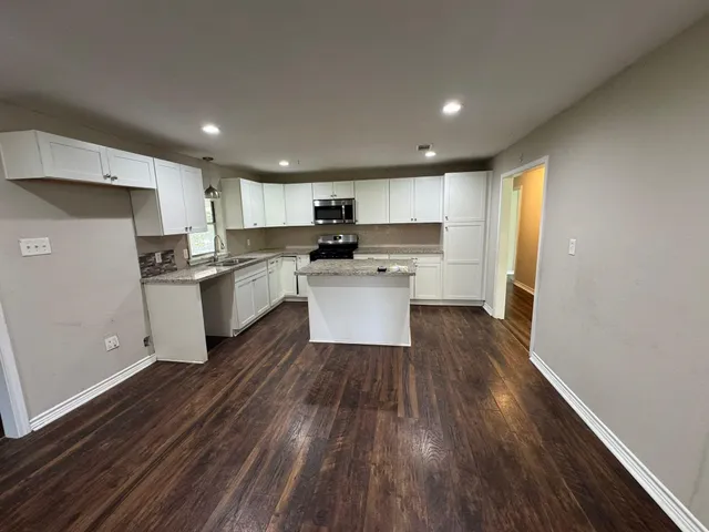 a kitchen with wooden floors and white appliances