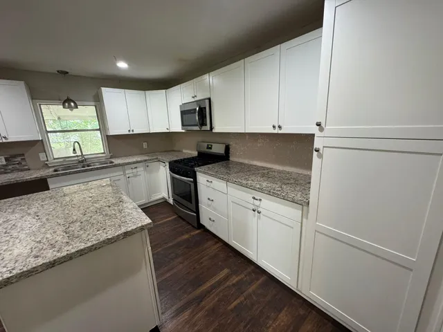 a kitchen with stainless steel appliances granite countertop a sink stove and refrigerator