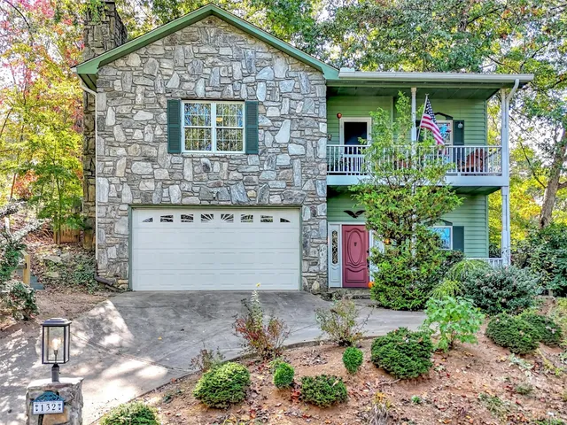 a front view of a house with a yard and trees