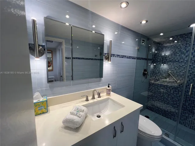 a bathroom with a sink mirror vanity and toilet