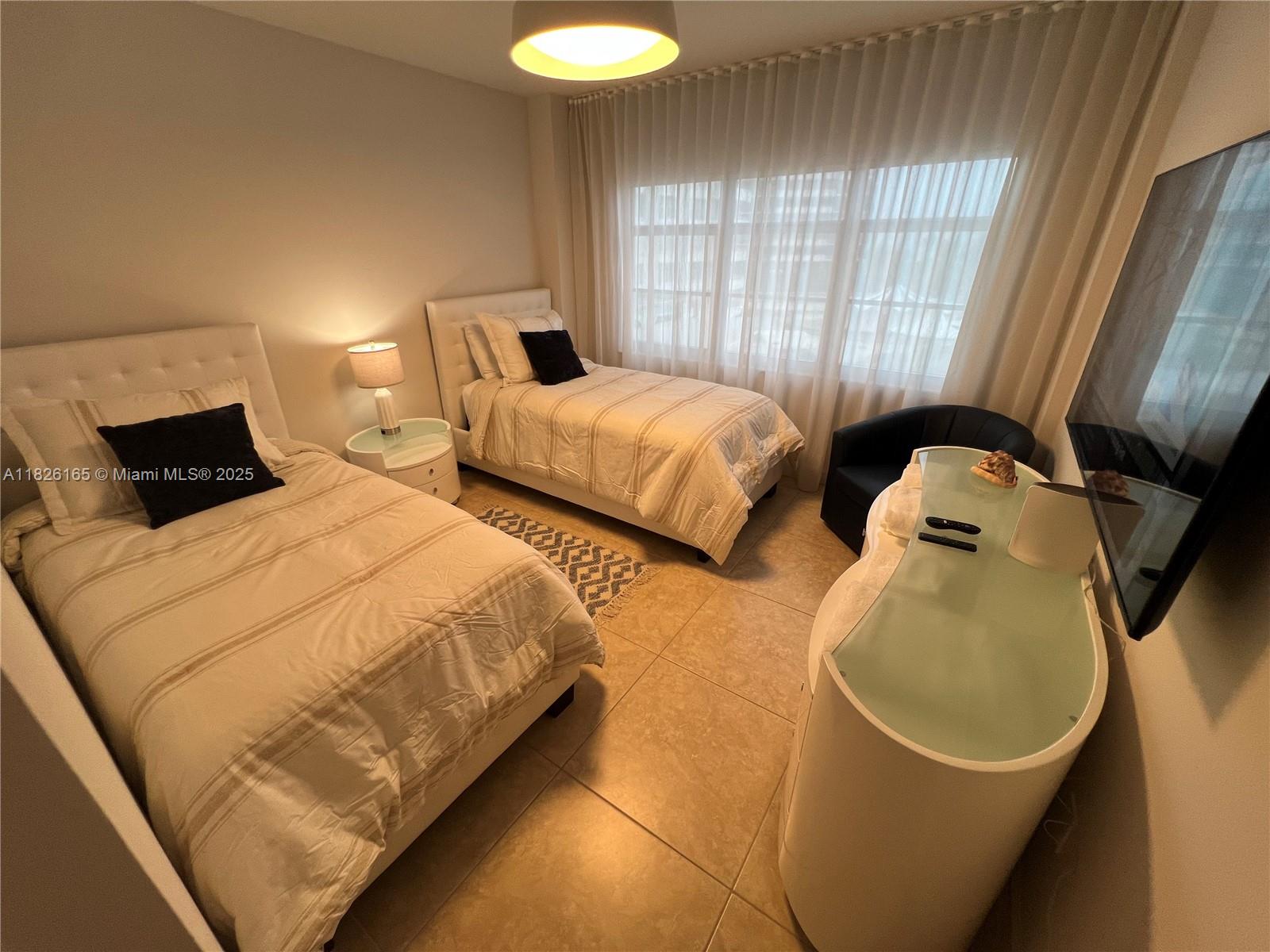 5151 Collins Avenue, Unit 535 Miami Beach, FL 33140 - Photo 18 of 34 a bedroom with two beds and a window