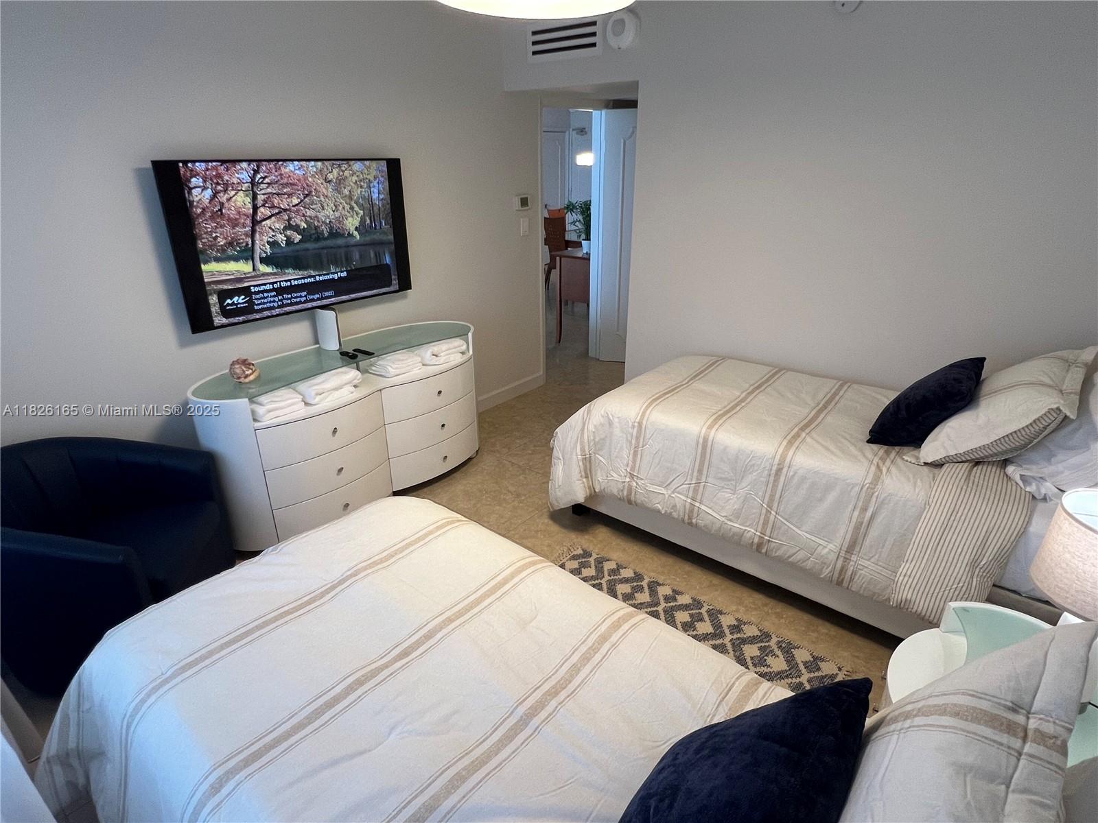 5151 Collins Avenue, Unit 535 Miami Beach, FL 33140 - Photo 19 of 34 a bedroom with a bed and a flat screen tv