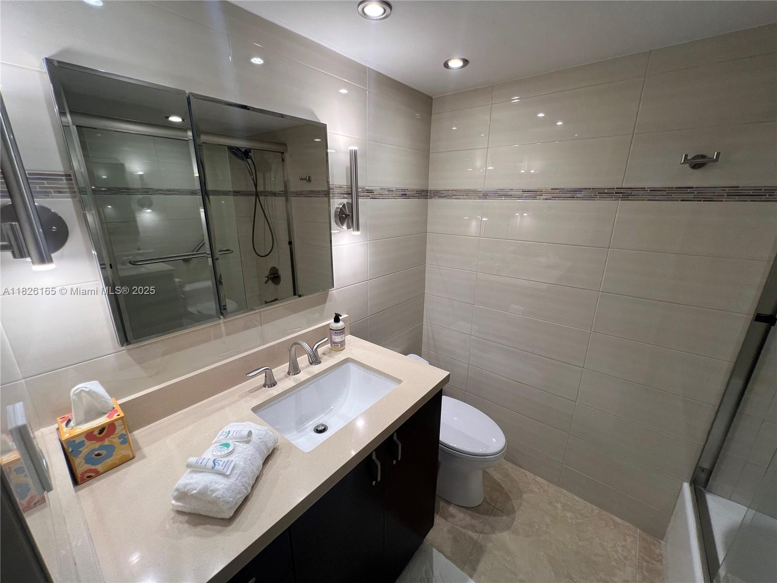 5151 Collins Avenue, Unit 535 Miami Beach, FL 33140 - Photo 21 of 34 a bathroom with a sink mirror vanity and toilet