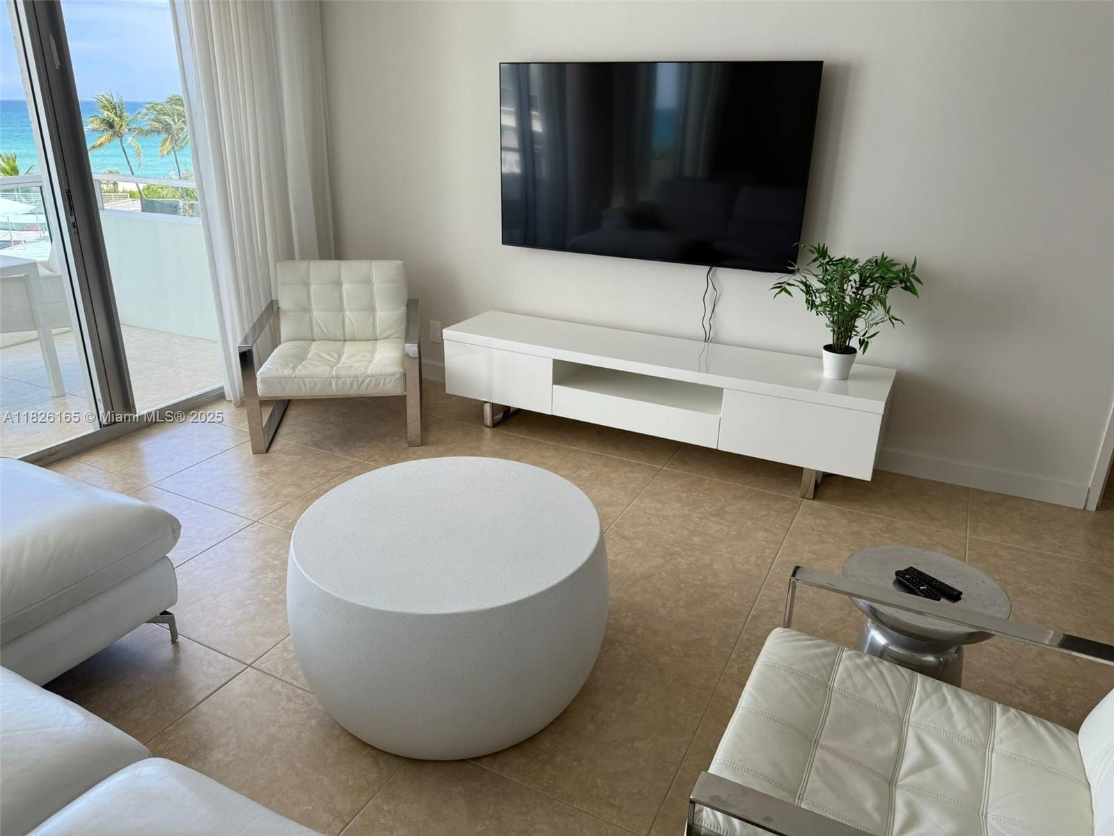 5151 Collins Avenue, Unit 535 Miami Beach, FL 33140 - Photo 9 of 34 a living room with furniture and a flat screen tv