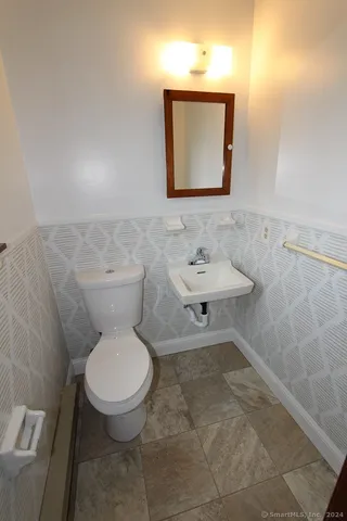 a bathroom with a toilet sink and mirror