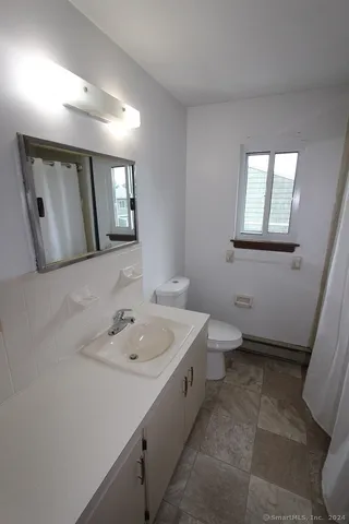 a bathroom with a toilet sink and mirror