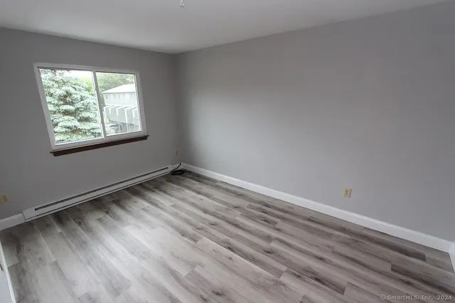 a view of an empty room with wooden floor
