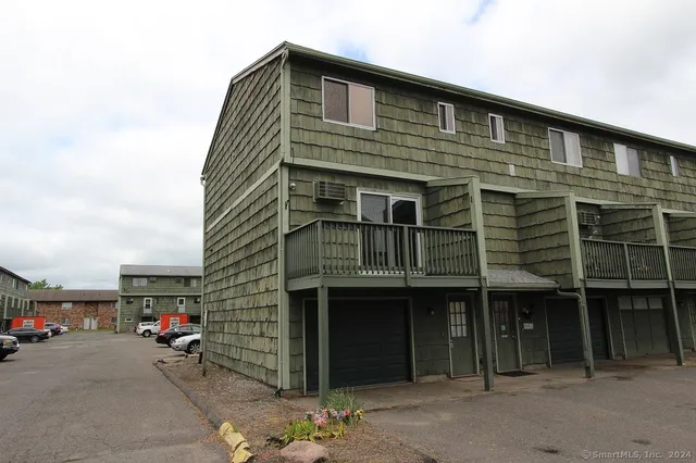 a front view of a house with a parking space
