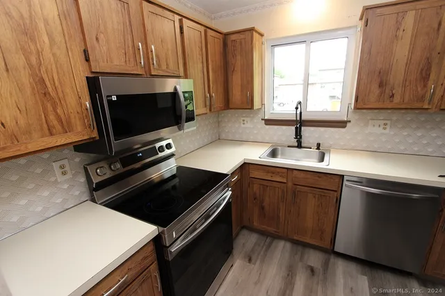 a kitchen with granite countertop a stove a sink and a microwave