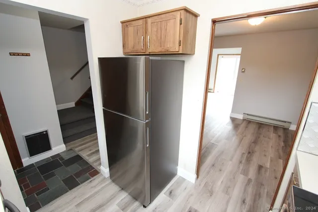 a view of a kitchen with wooden floor and electronic appliances