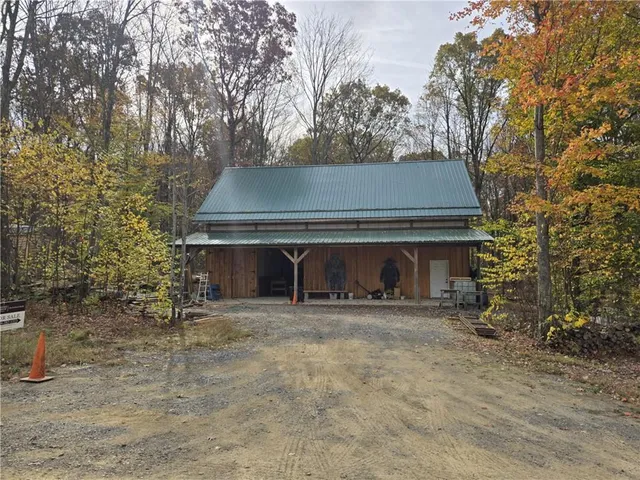 a front view of a house with yard and trees