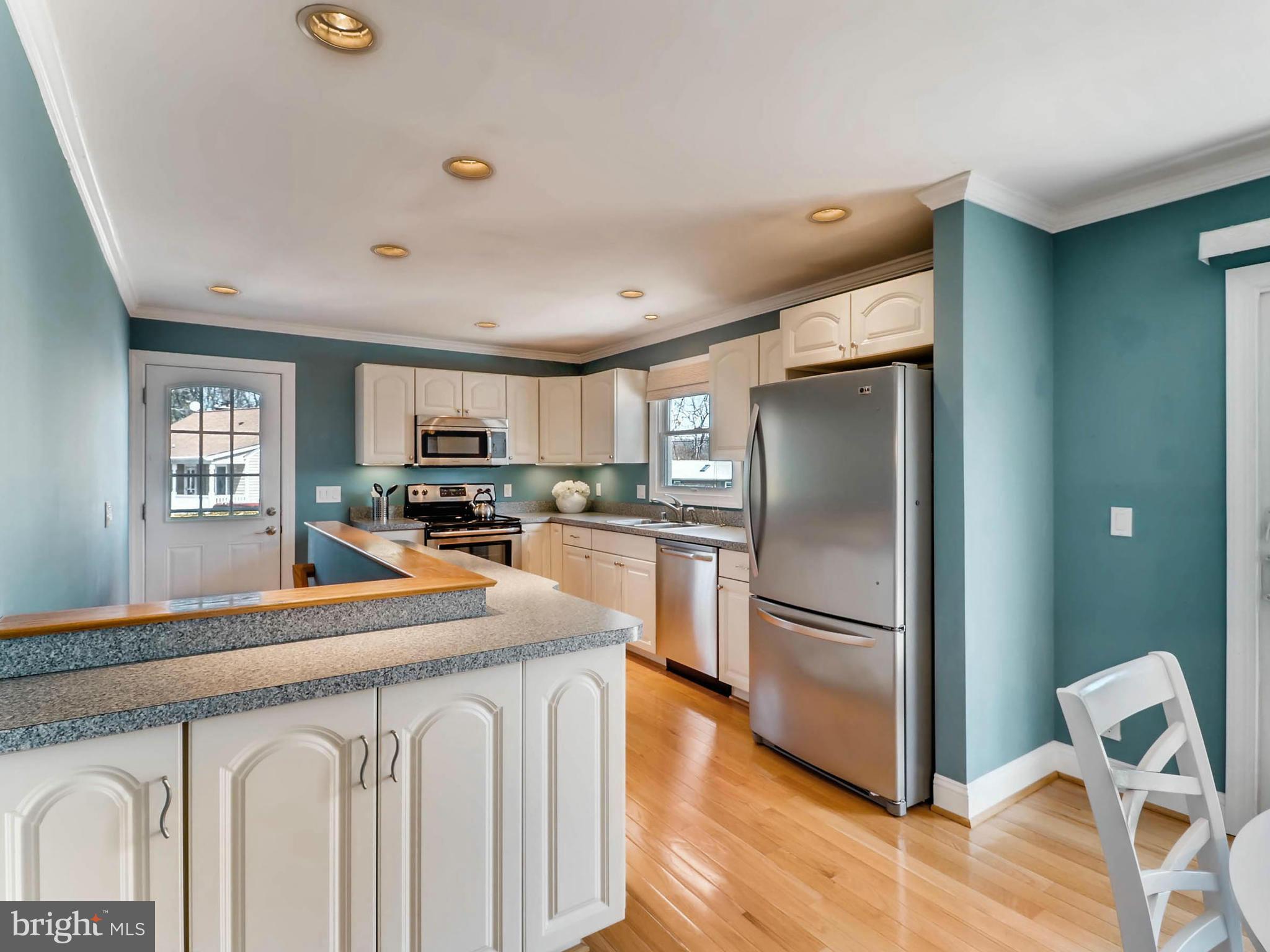 173 Copper Road Severna Park, MD 21146 - Photo 9 of 29 a kitchen with stainless steel appliances granite countertop a refrigerator a stove and a sink with wooden floor