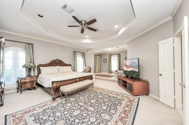 a spacious bedroom with a bed window and table chair