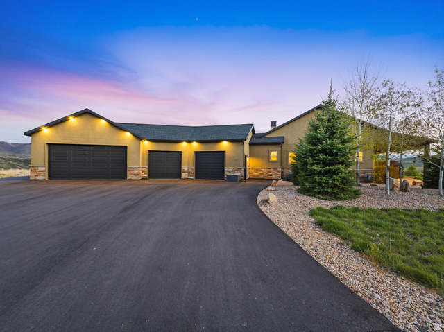 402 Shadow Hill Road Wanship, UT 84017 - Photo 81 of 90 View of front facade featuring stucco siding, stone siding, an attached garage, and asphalt driveway