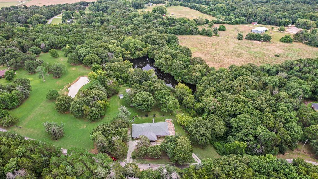 298 Butterfield Road Denison, TX 75021 - Photo 34 of 34 Expansive property featuring a single-story residence, a private pond, mature trees, a natural water feature, and open grassy areas