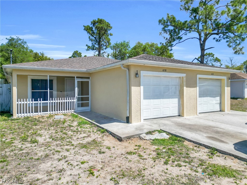 4716-4718 21st Street Southwest Lehigh Acres, FL 33973 - Photo 1 of 21 a front view of a house with a yard and garage