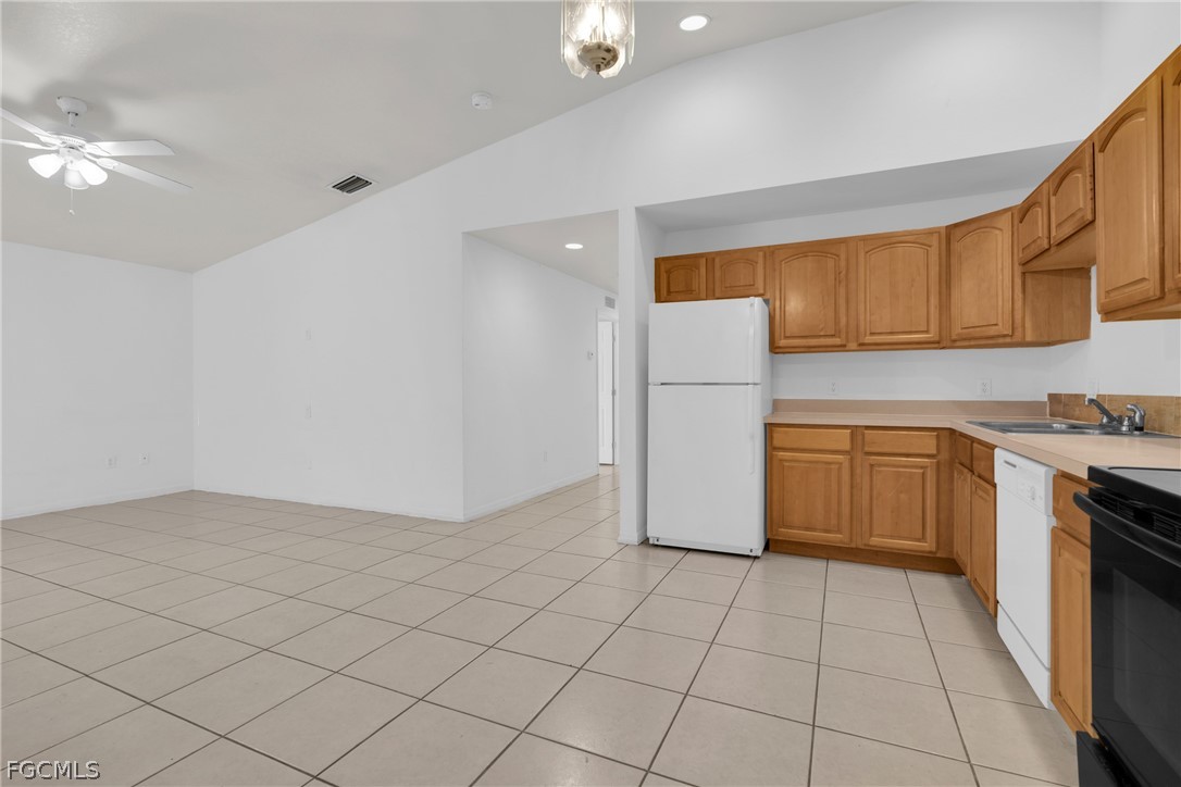 4716-4718 21st Street Southwest Lehigh Acres, FL 33973 - Photo 16 of 21 a kitchen with a stove a refrigerator and cabinets