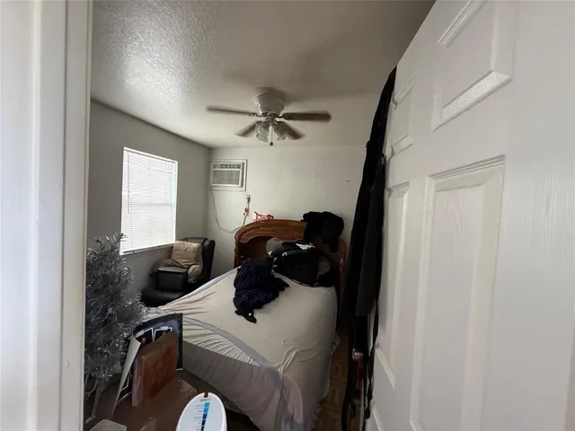 a bedroom with a bed and a ceiling fan