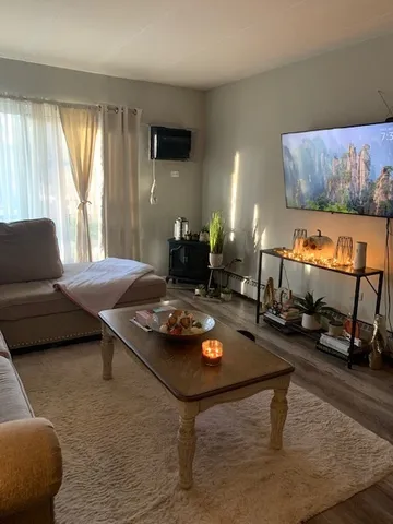 a dining room with wooden floor a chandelier a wooden table and chairs