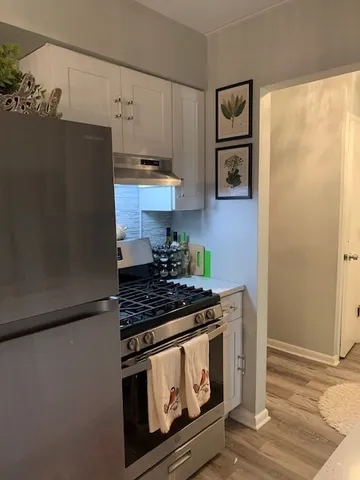 a kitchen with stainless steel appliances granite countertop a refrigerator a stove and a sink with dishwasher