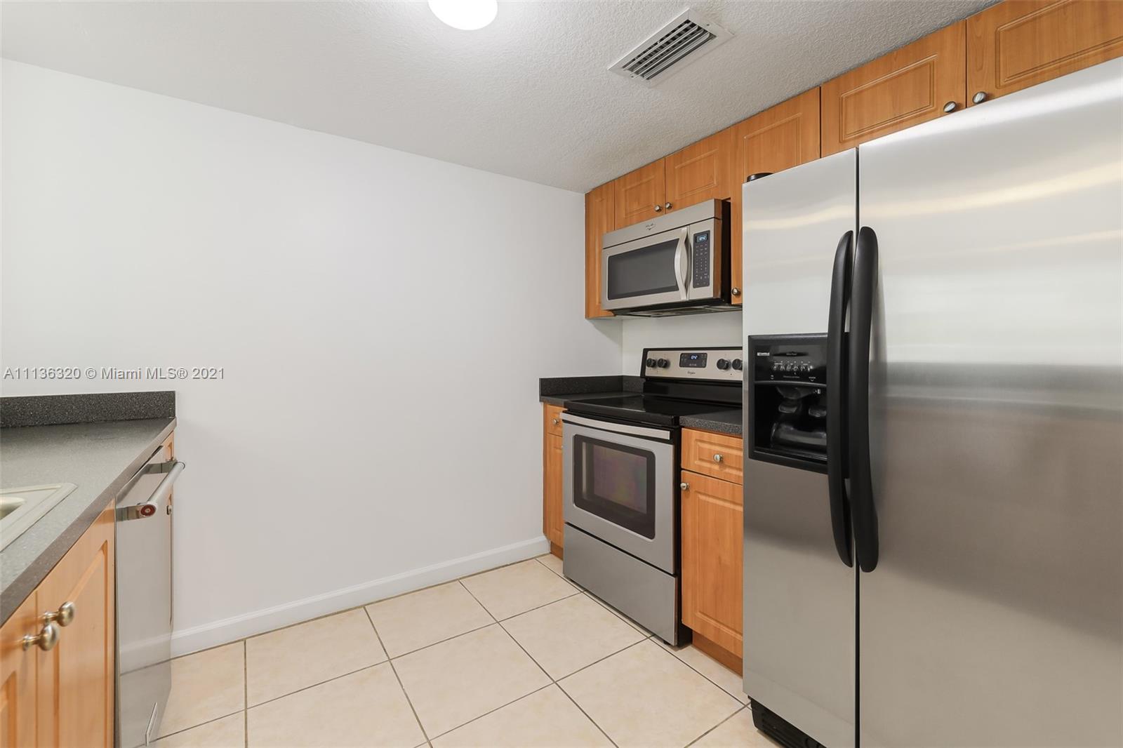 280 Southwest 20th Road, Unit 404 Miami, FL 33129 - Photo 16 of 52 a kitchen with stainless steel appliances granite countertop a refrigerator and a stove top oven