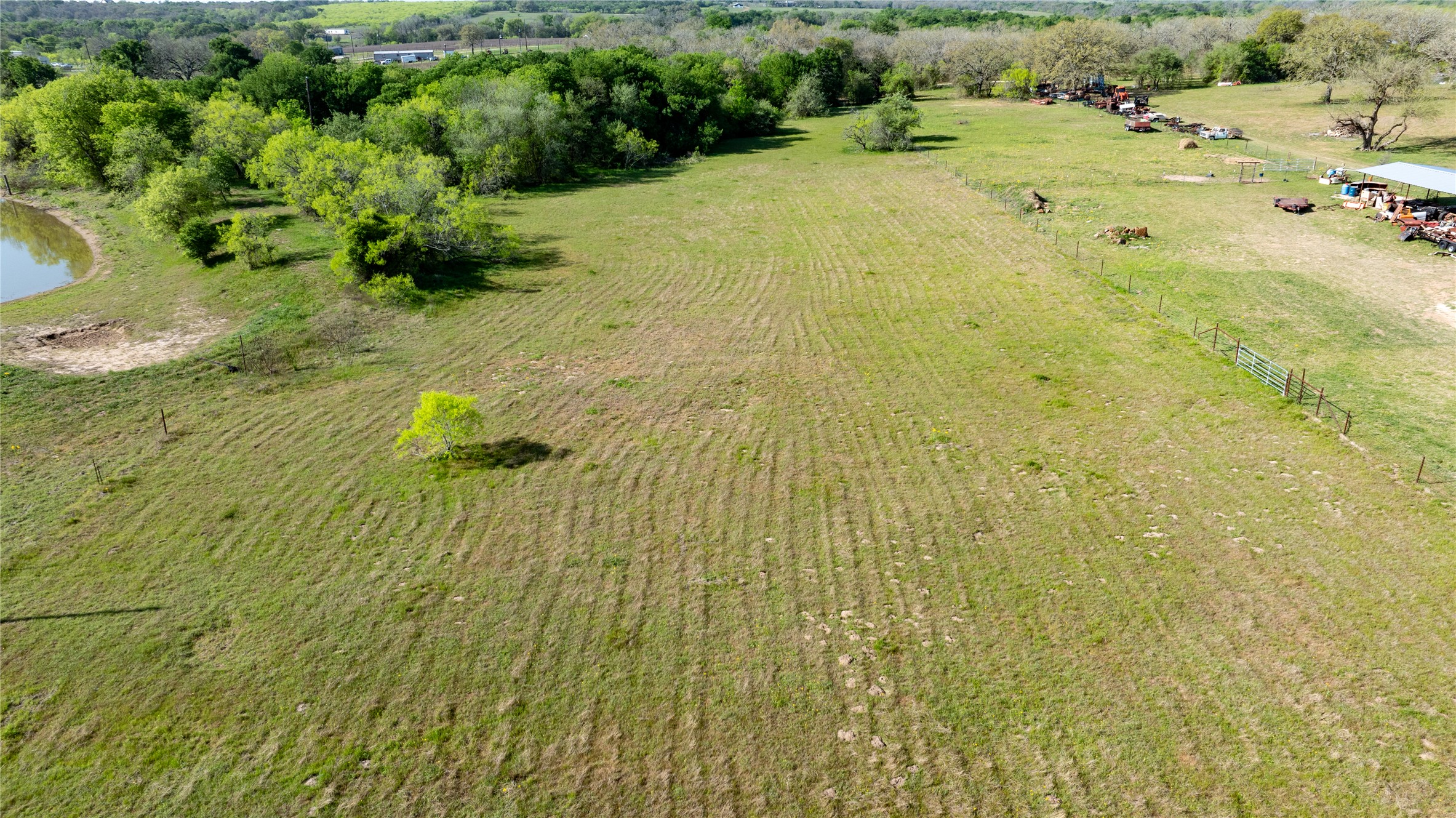 6575 Taylorsville Road Dale, TX 78616 - Photo 7 of 15 A verdant, open field with mature trees, offering a private pond and ample space.