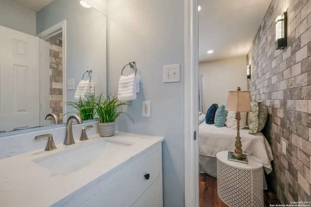 a bathroom with a sink a potted plant and a mirror