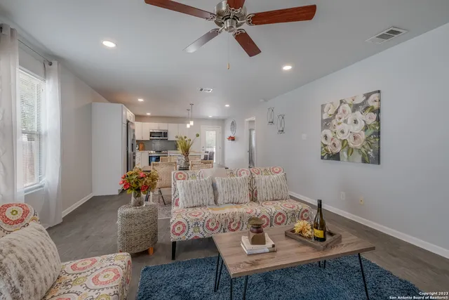 a living room with furniture and view of kitchen