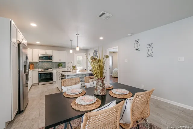 a dining room with furniture a table and kitchen view