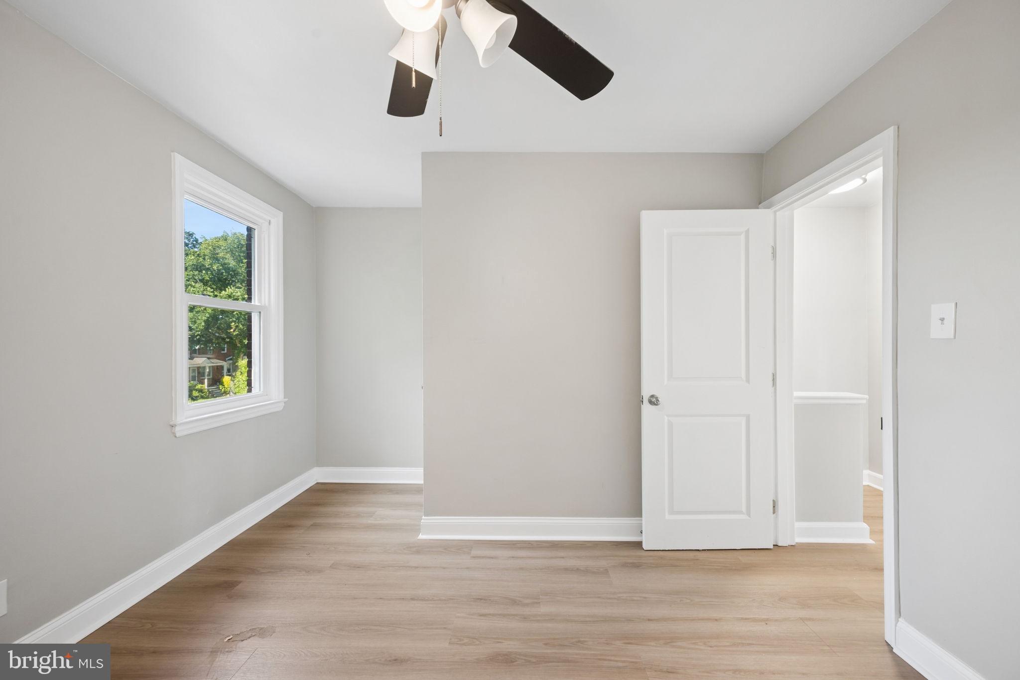 3548 Benzinger Road Baltimore, MD 21229 - Photo 24 of 40 an empty room with wooden floor chandelier fan and windows