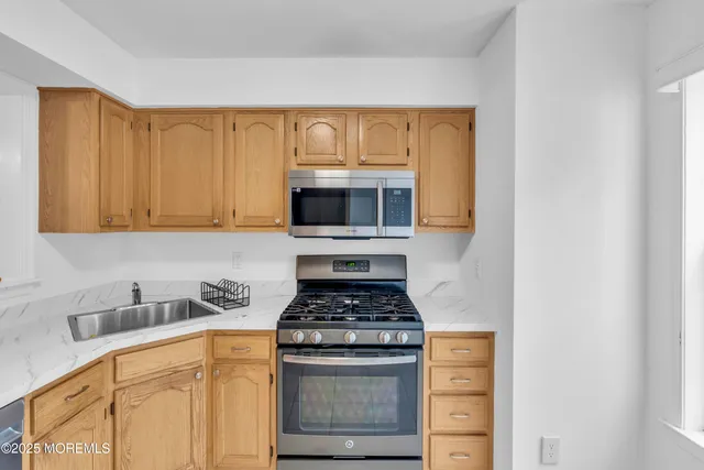 a kitchen with granite countertop a stove and a microwave