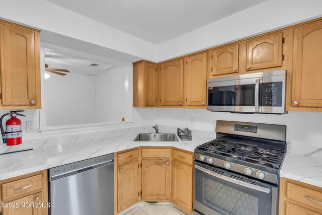 a kitchen with stainless steel appliances granite countertop a sink stove and microwave