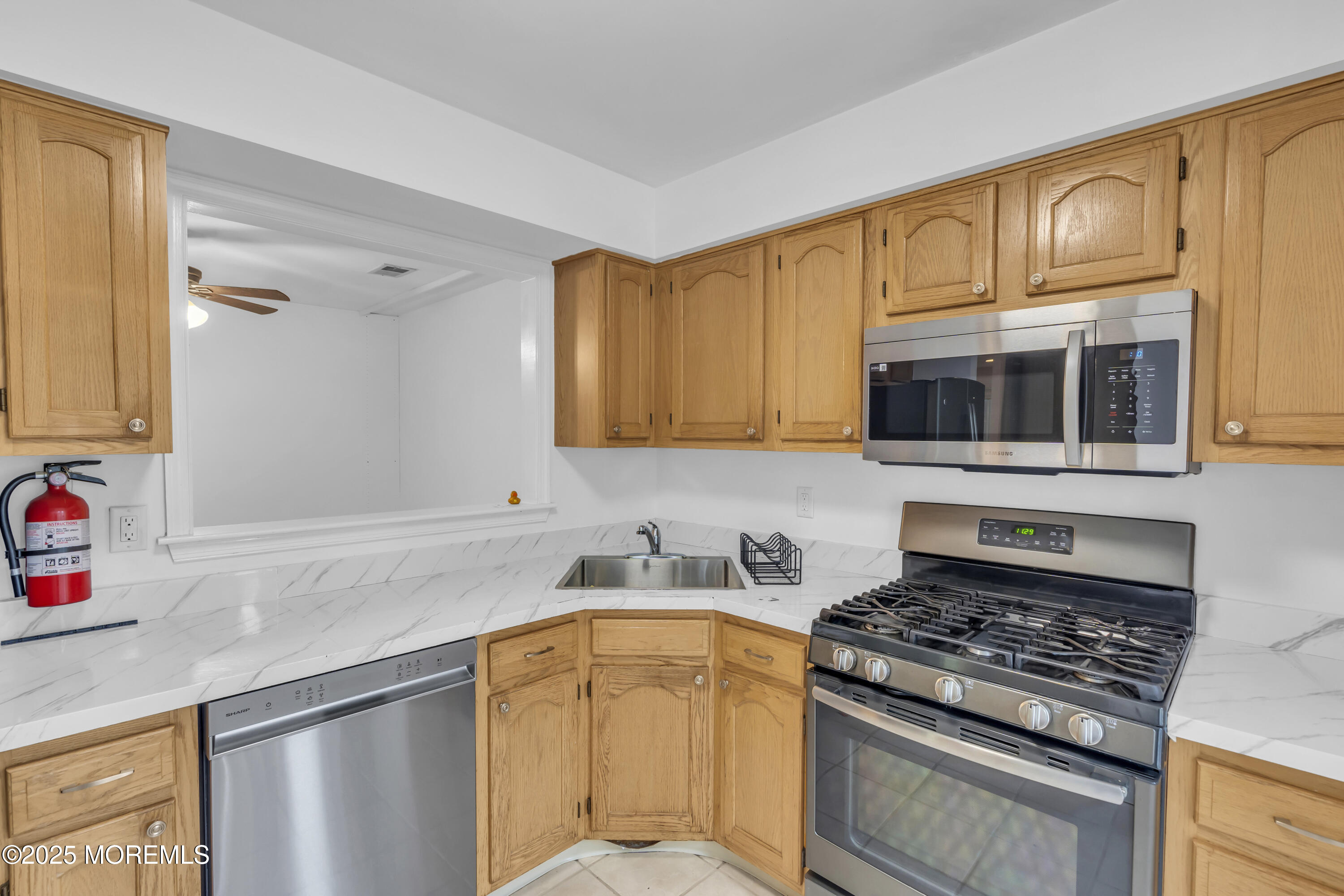 237 Paddington Court, Unit 87 Manalapan, NJ 07726 - Photo 12 of 23 a kitchen with stainless steel appliances granite countertop a sink stove and microwave