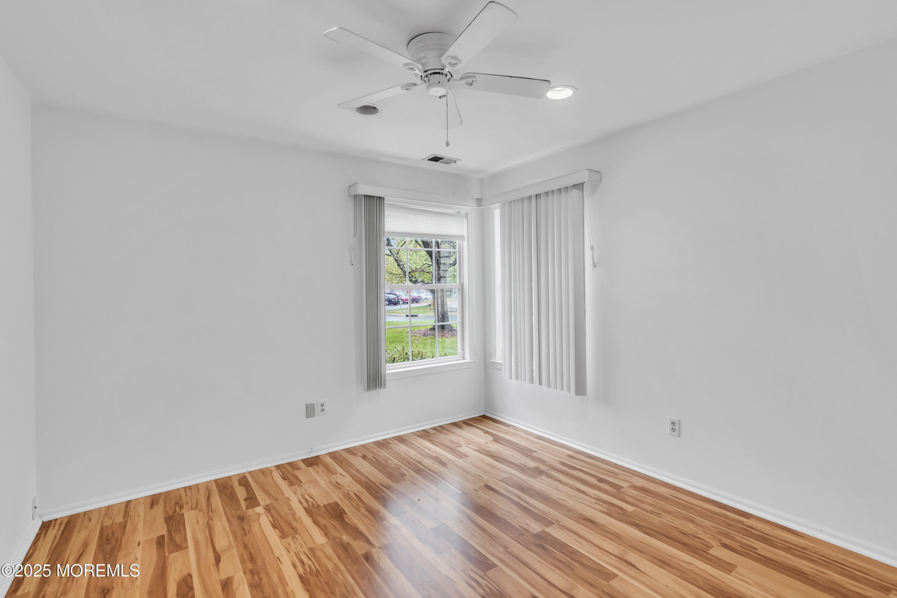 237 Paddington Court, Unit 87 Manalapan, NJ 07726 - Photo 14 of 23 wooden floor in an empty room with a window
