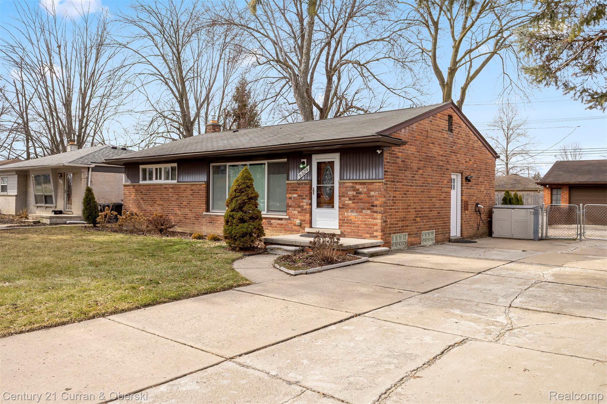 9329 Merriman Road Livonia, MI 48150 - Photo 3 of 32 View of front of property with brick siding, a gate, a chimney, and concrete driveway